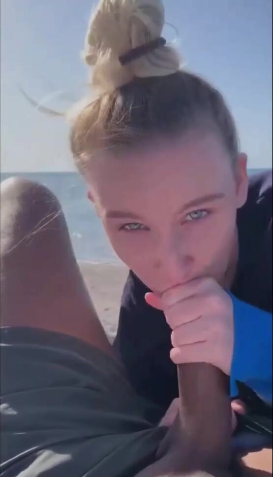 Nena británica chupa una gran polla negra en la playa